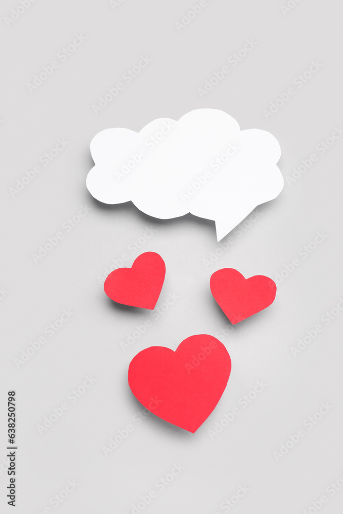 Paper hearts with blank speech bubble on grey background