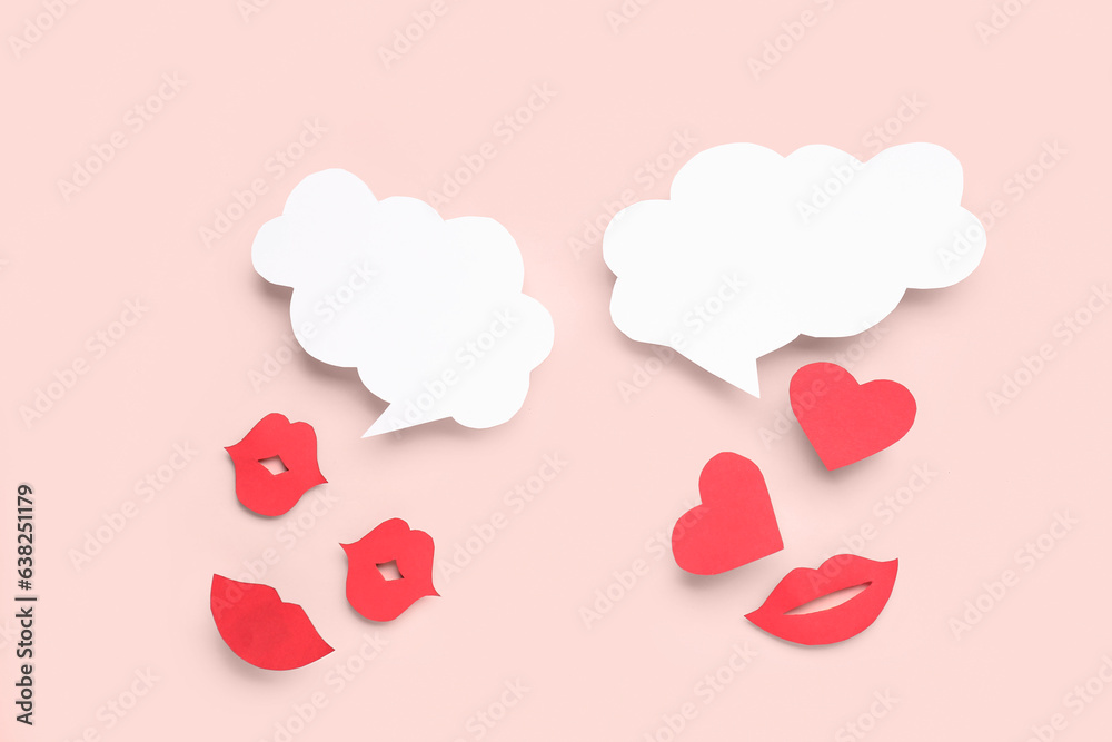 Paper lips and and hearts with blank speech bubbles on pink background