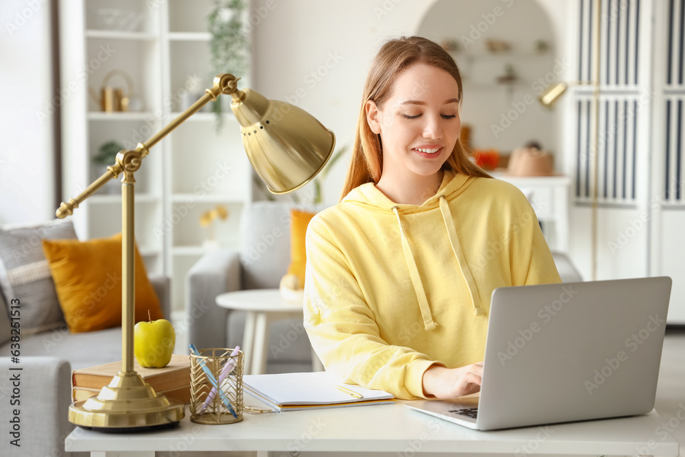 Female student studying with laptop at home