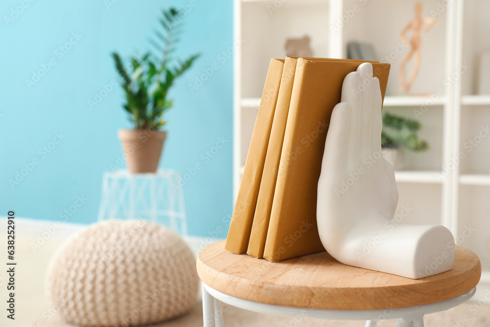 Stylish holder for books on coffee table in room