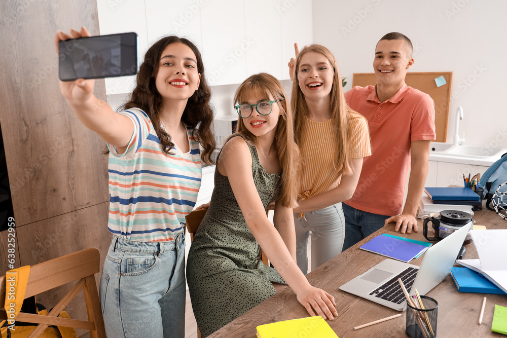 Group of students taking selfie in kitchen