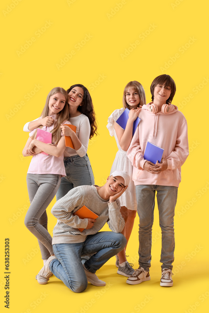 Group of students with copybooks on yellow background