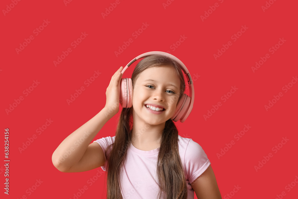 Little girl in headphones on red background