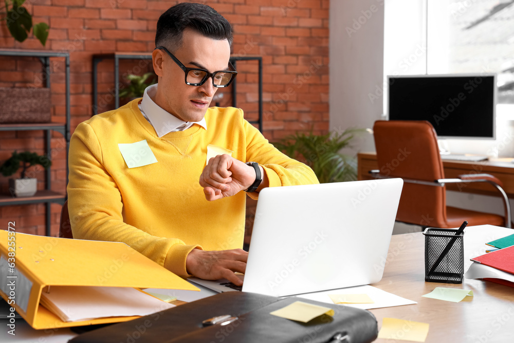 Stressed businessman working under deadline in office