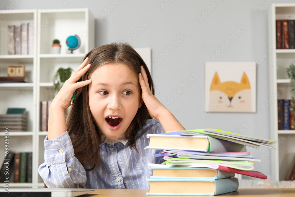 Shocked little girl with books at home