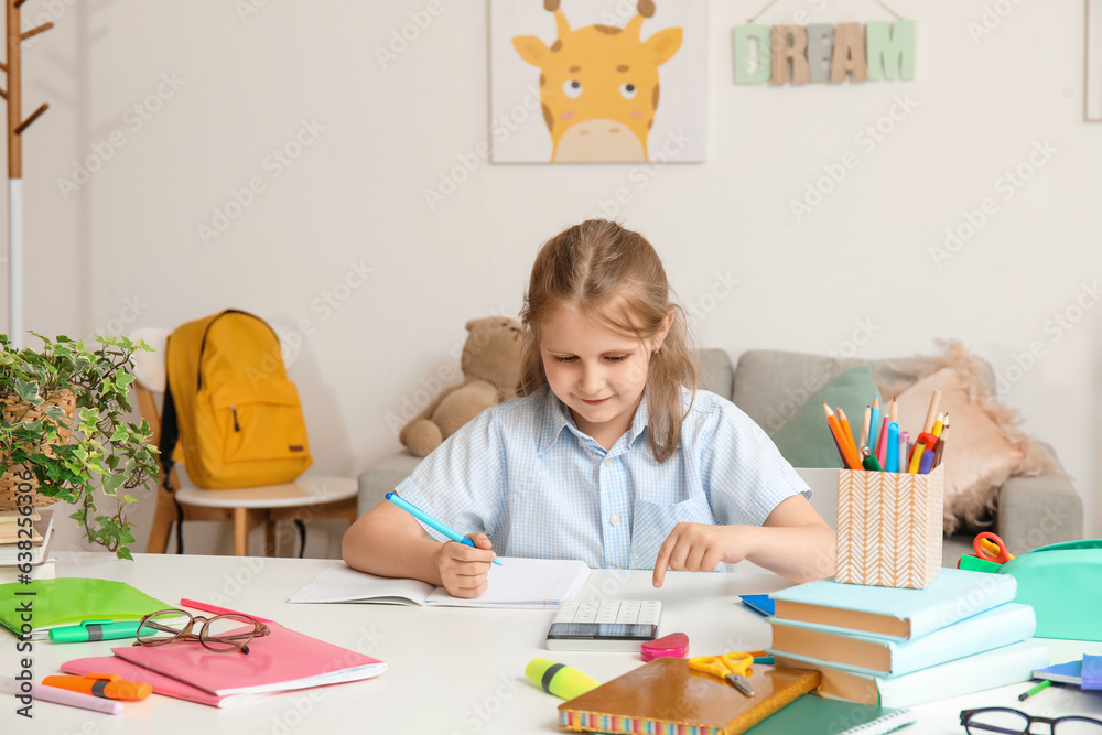 Cute little girl with calculator doing Math at home