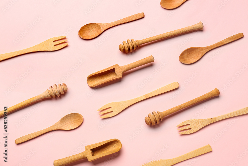 Wooden kitchen utensils on pink background