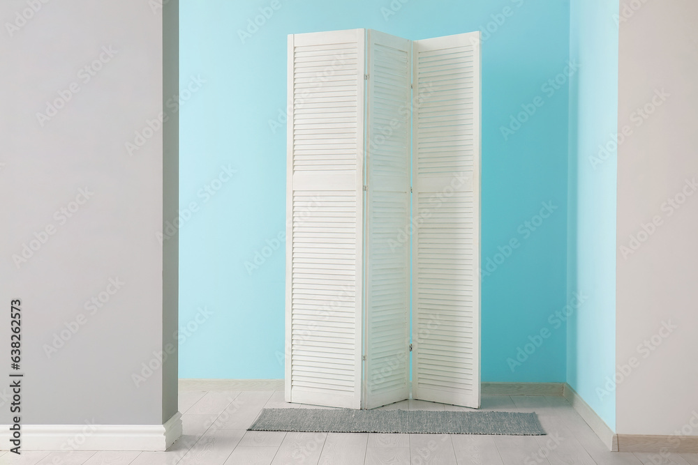 Folding screen and carpet near colorful wall