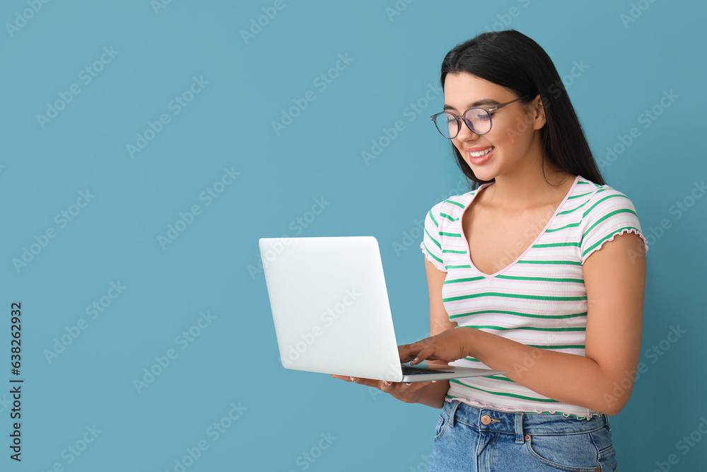 Happy female programmer working with laptop on blue background