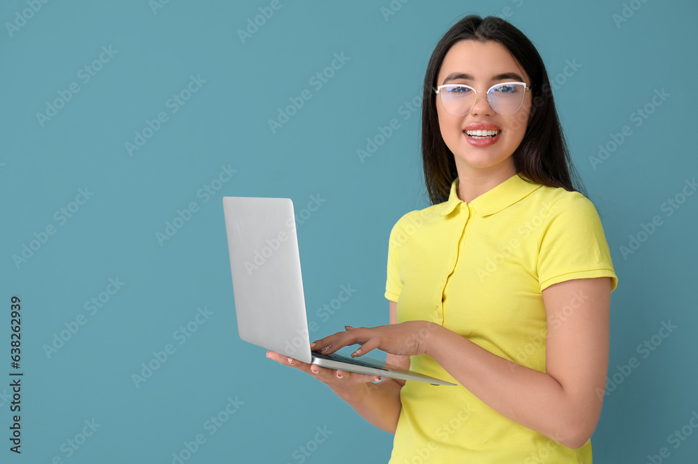 Young female programmer working with laptop on blue background