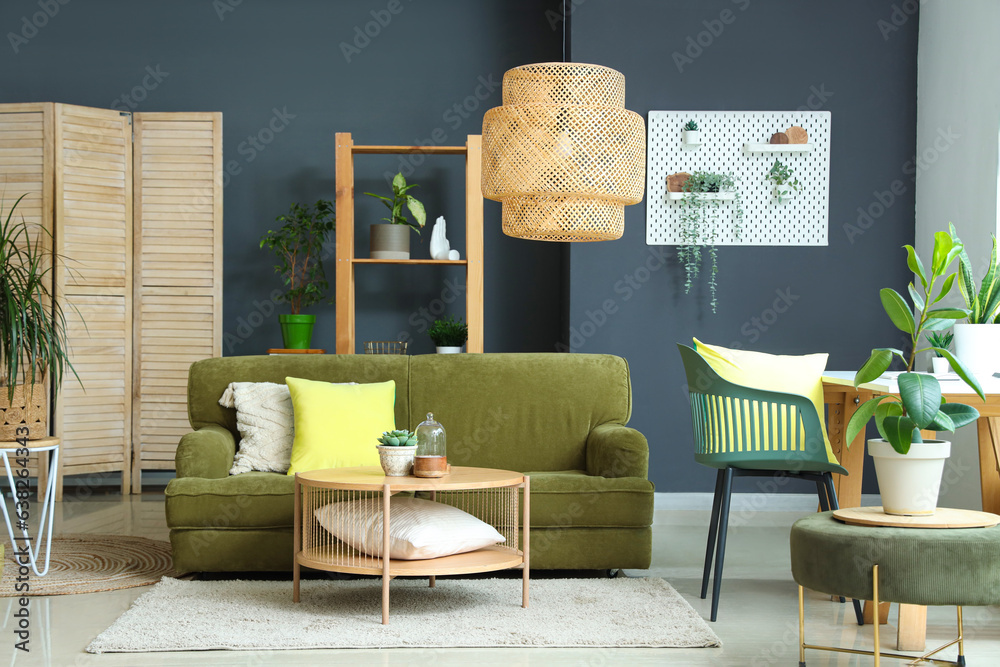 Interior of modern living room with plants, sofa and workplace