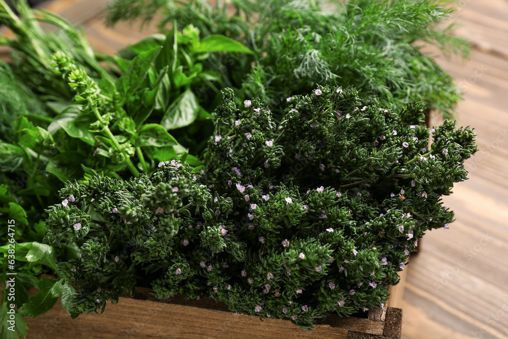 Basket with fresh herbs on wooden background, closeup