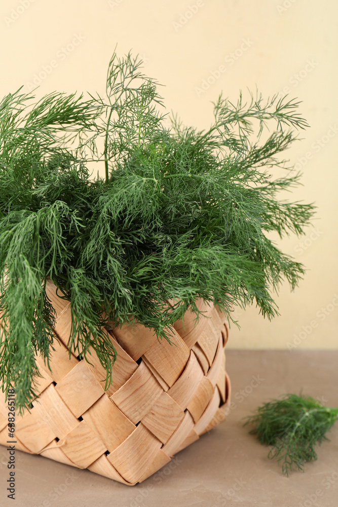 Wicker basket with fresh dill on color background, closeup