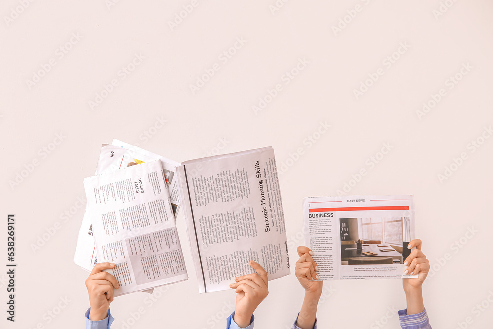 Female hands with different newspapers on light background