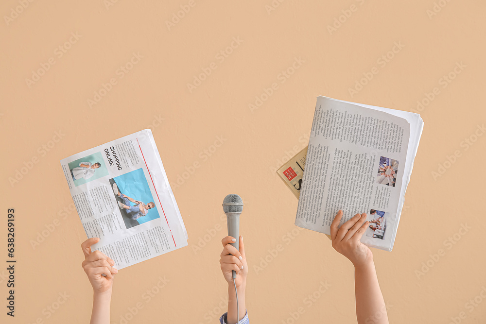 Female hands with microphone and newspapers on color background