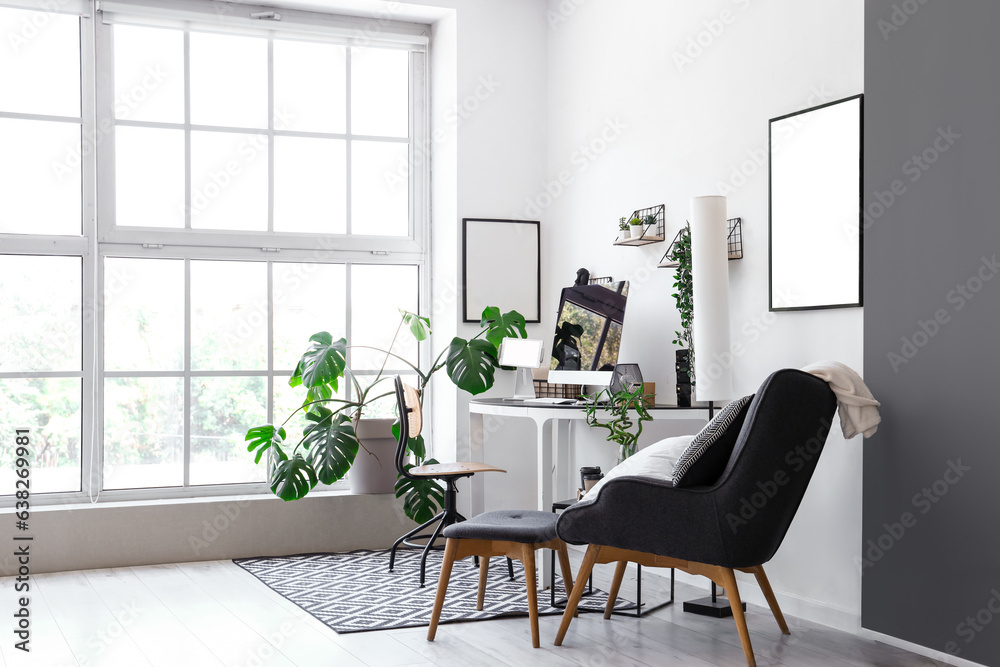 Interior of light office with modern workplace and houseplants