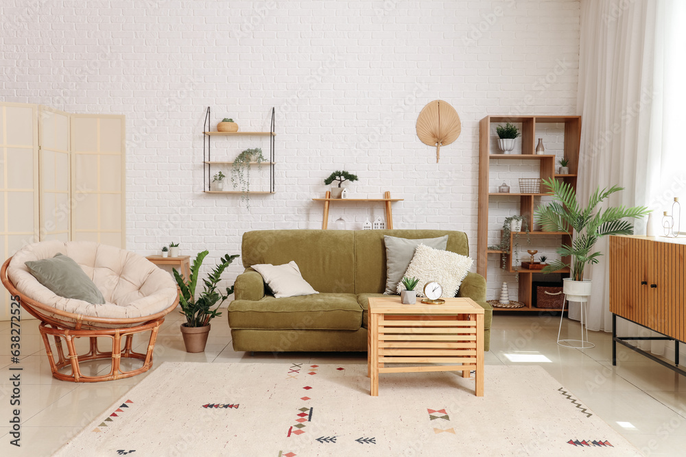 Interior of stylish living room with cozy armchair and green sofa