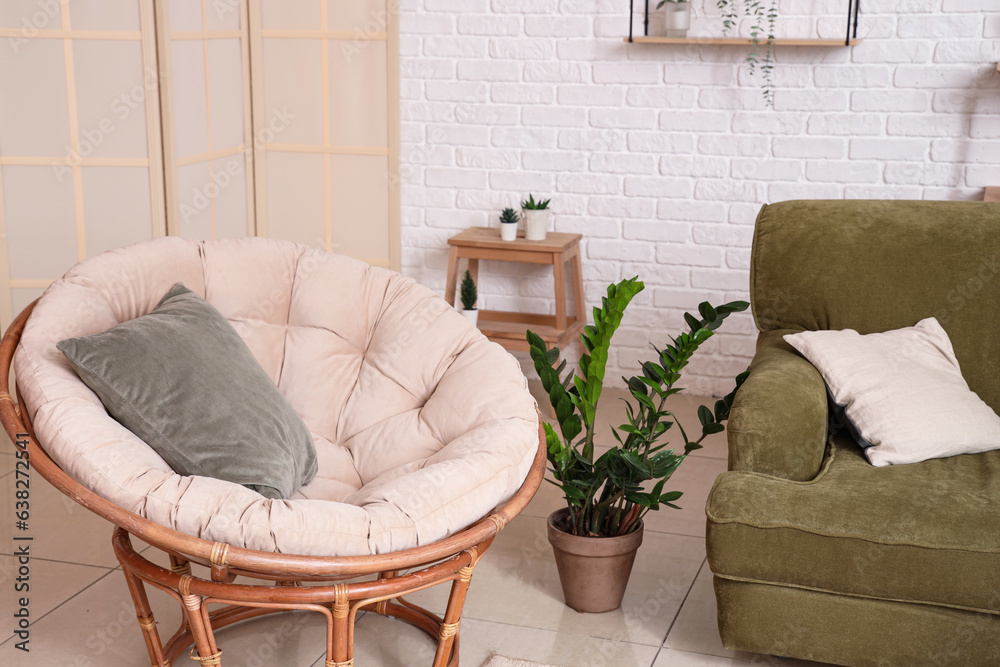 Interior of stylish living room with cozy armchair and green sofa