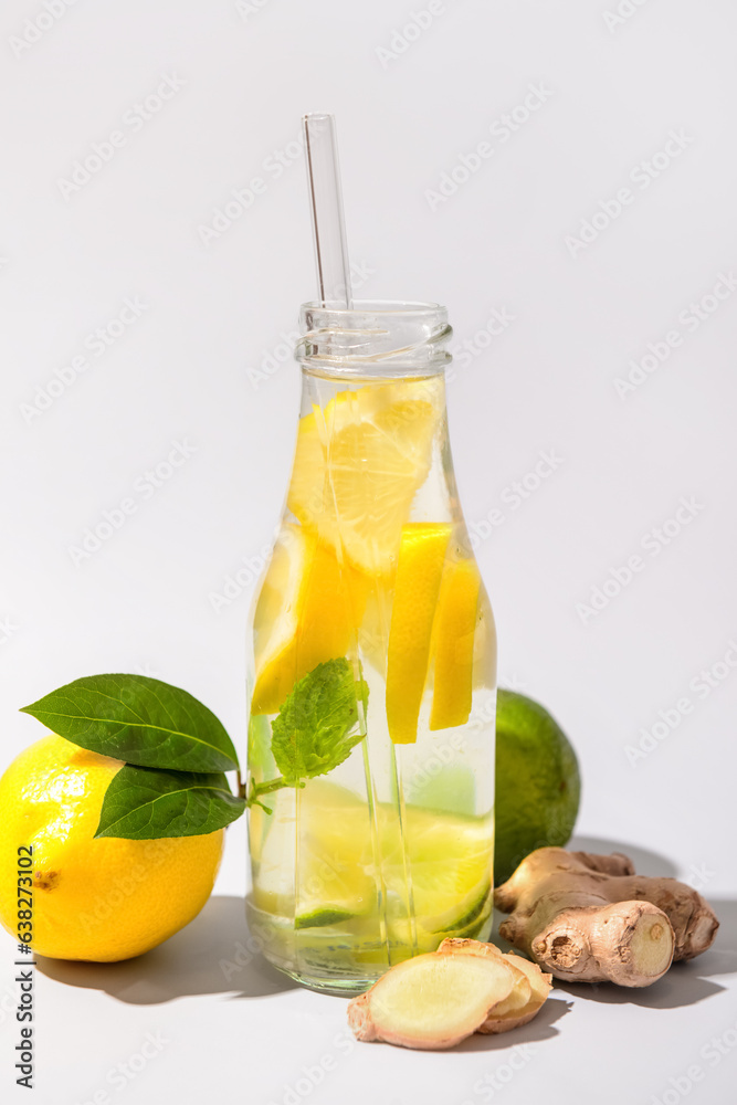 Bottle of tasty lemonade with lime and ginger on white background