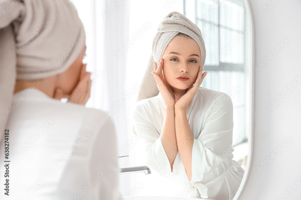 Young woman after shower near mirror in bathroom