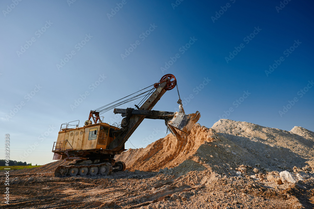 Shovel mining excavator takes chalk from pile in open quarry