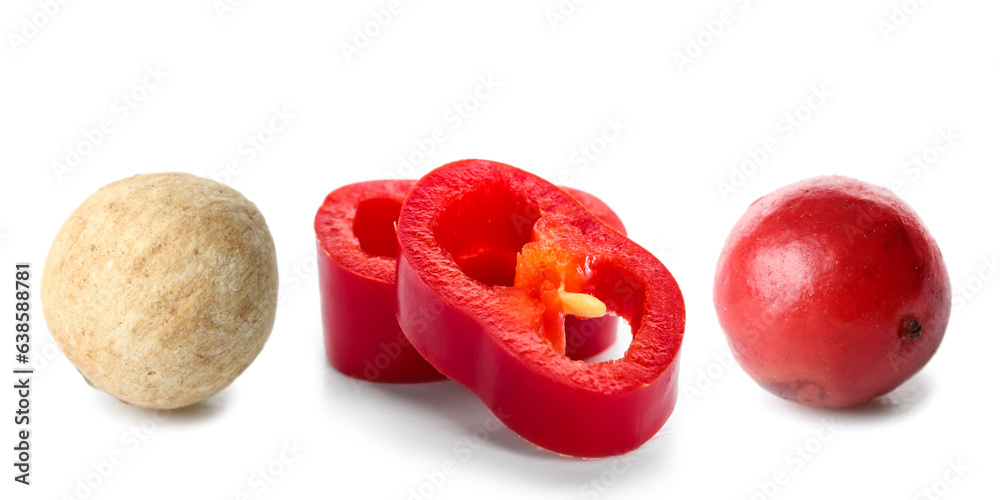 Cut chili peppers and peppercorn on white background