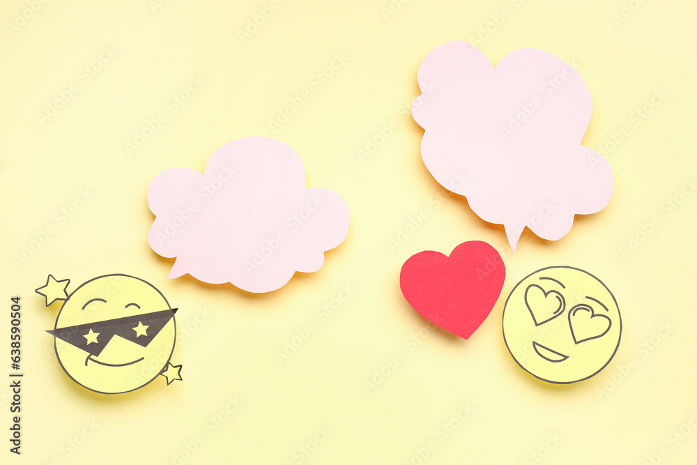 Paper faces with blank speech bubbles and heart on yellow background