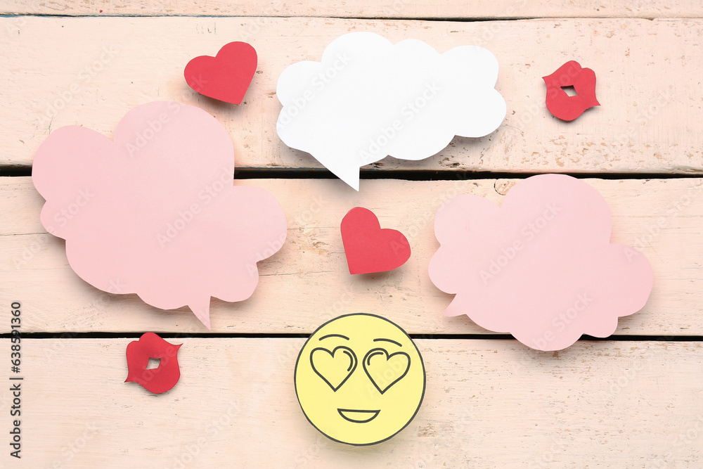 Paper face, lips with blank speech bubbles on beige wooden background