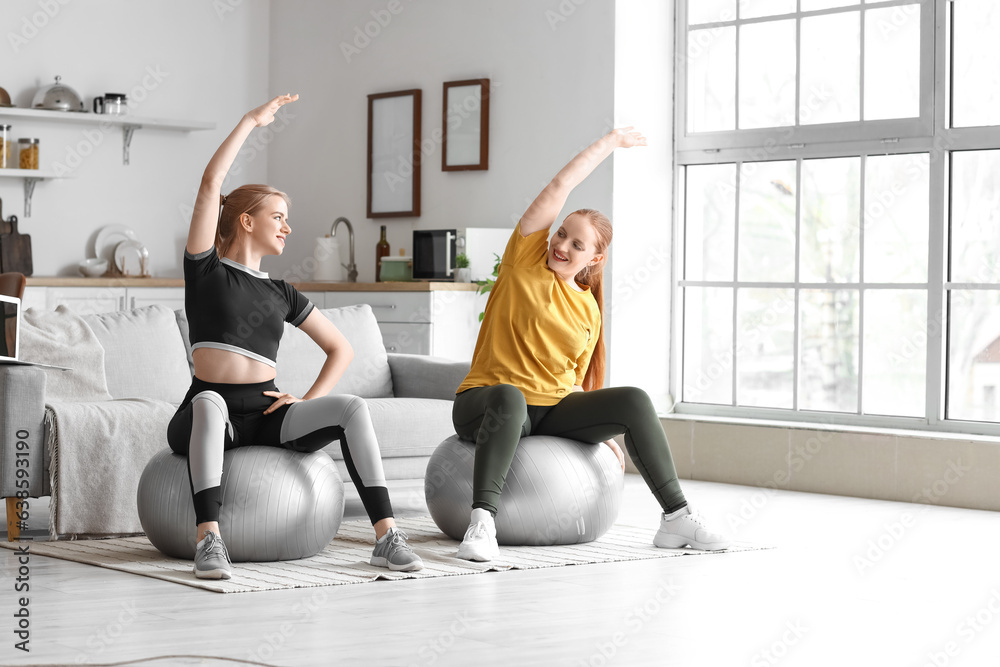 Sporty young women training with fitballs at home