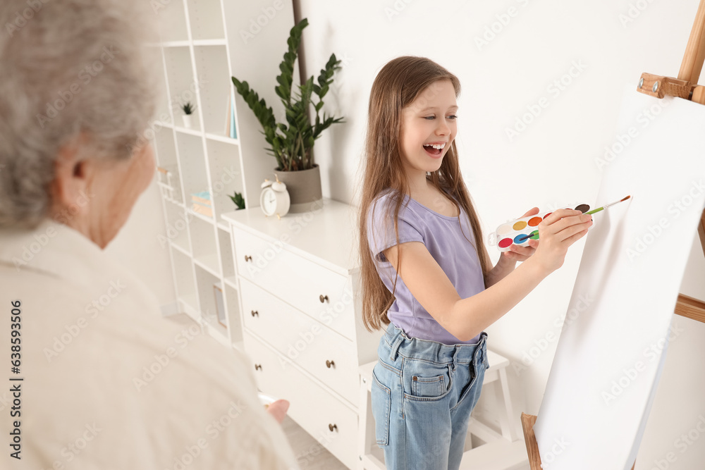 Little girl with her grandmother drawing at home