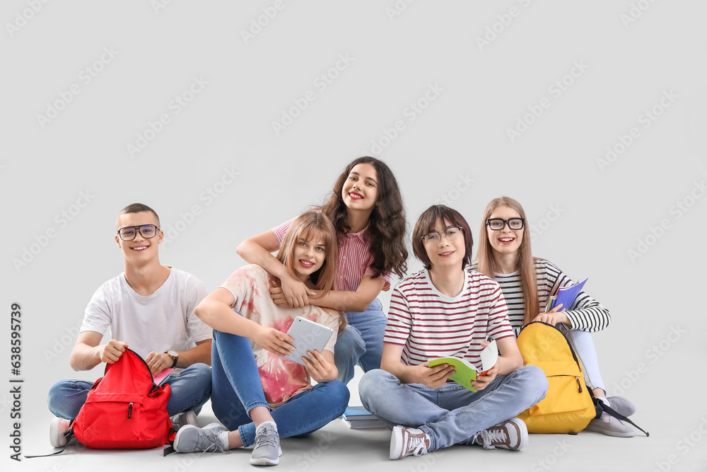 Group of students sitting on light background