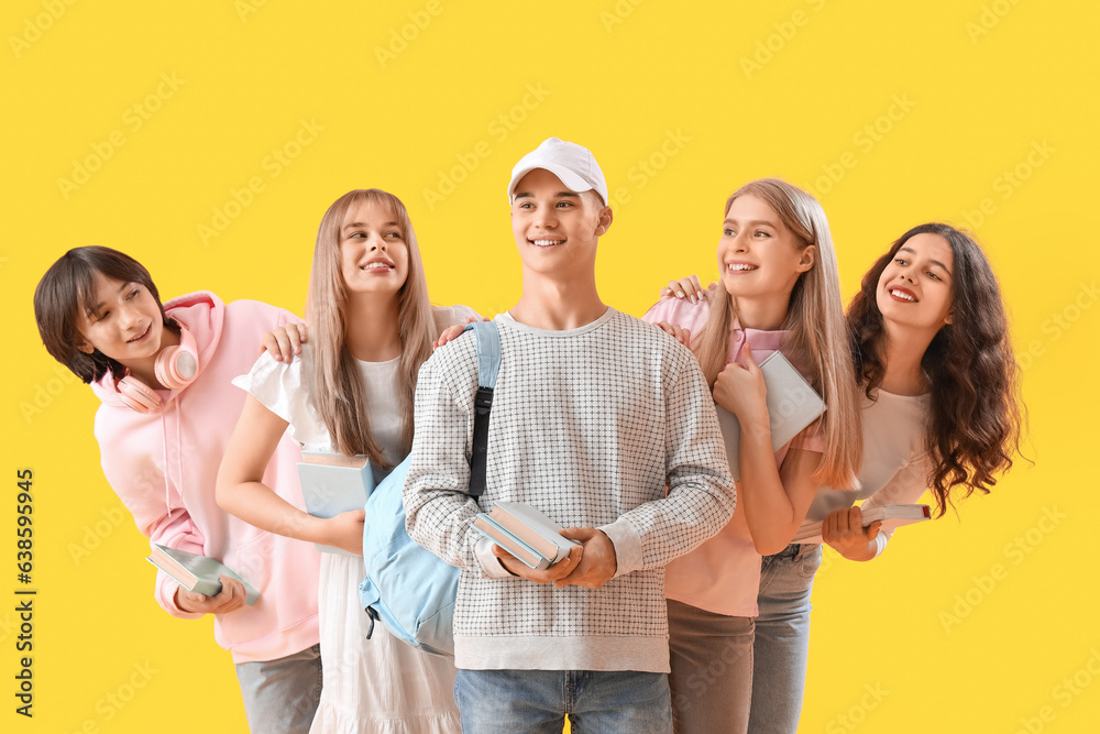 Group of students with books on yellow background