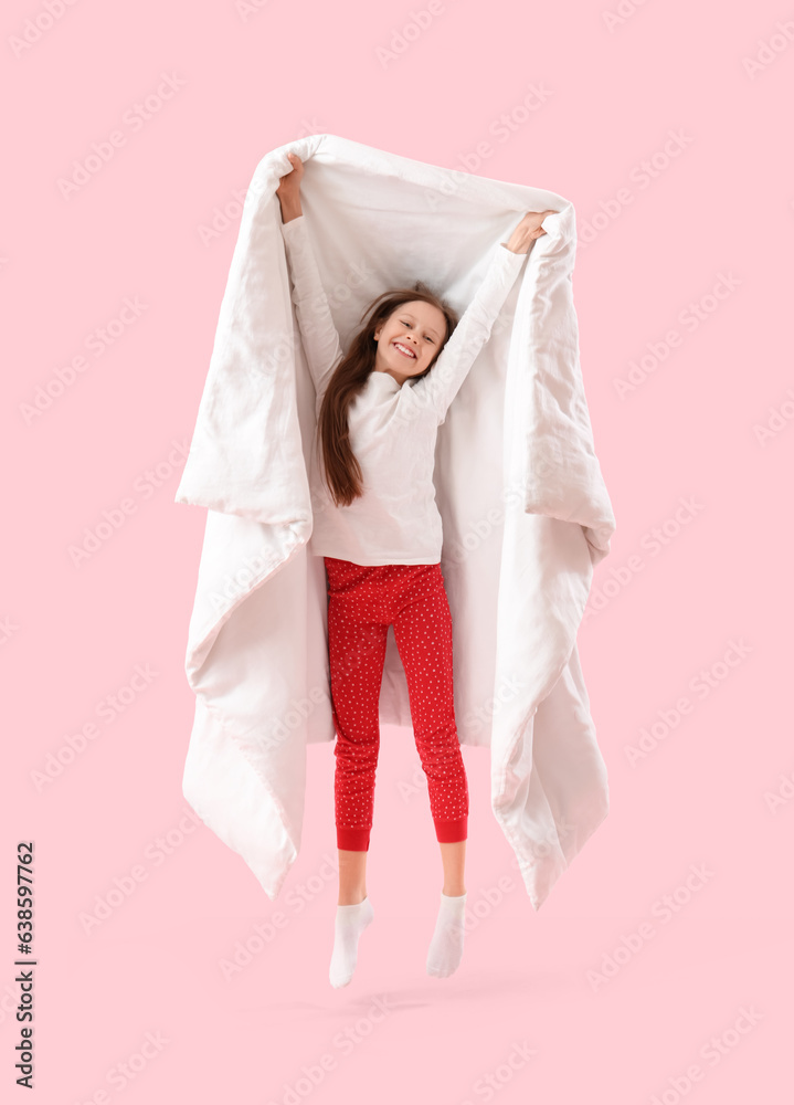 Jumping little girl with blanket on pink background