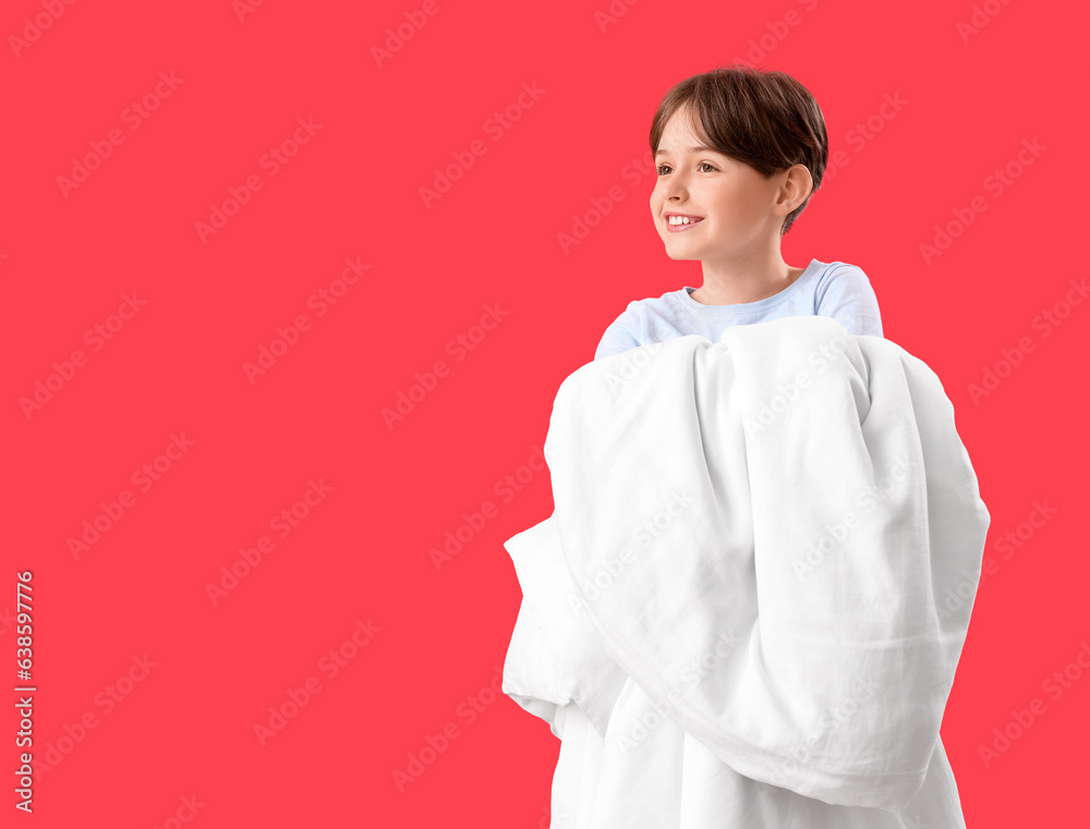 Little boy with blanket on red background