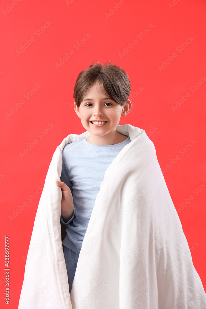 Little boy with blanket on red background