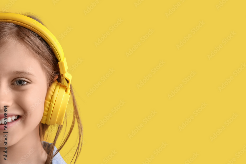 Little girl in headphones on yellow background, closeup