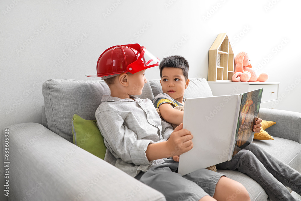 Cute little boys reading story at home