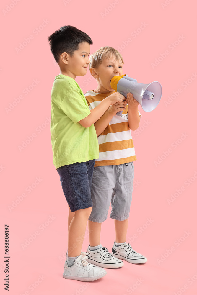 Cute little boys with megaphone on pink background