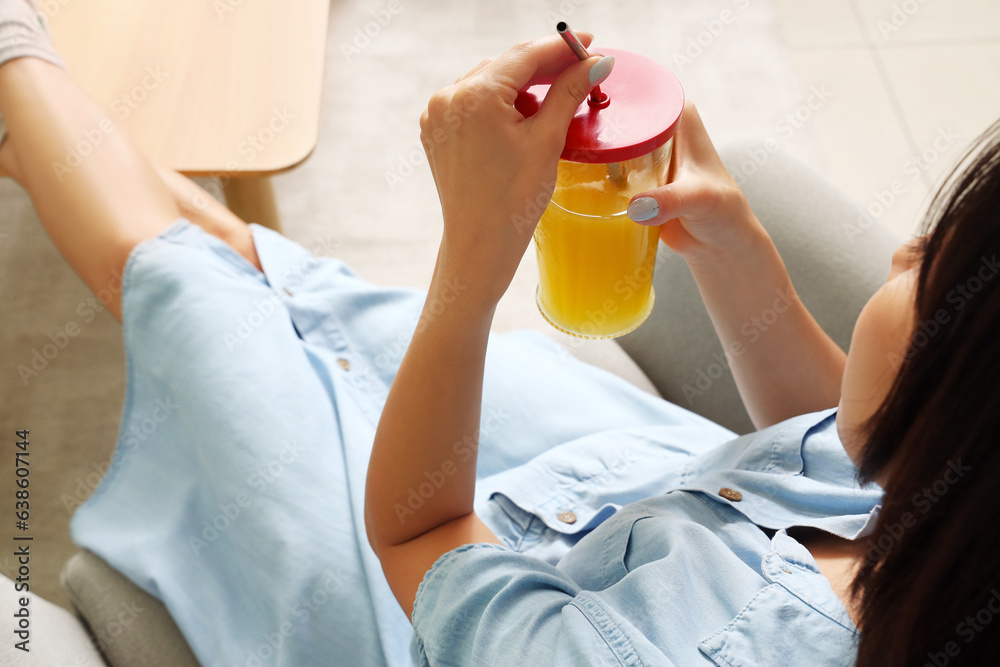 Beautiful Asian woman with glass of juice at home, closeup