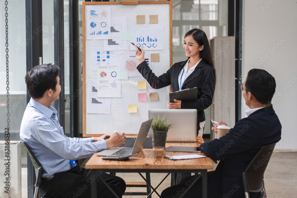 Businesswoman presenting data analysis on a board to her colleagues in the company