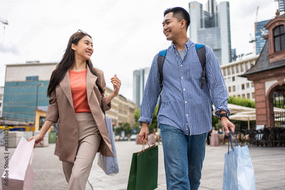 Asian young man and woman shopping goods outdoors in department store. 