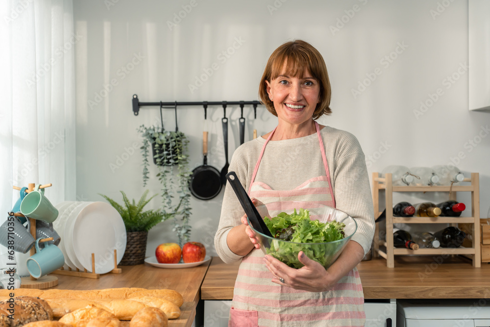 Portrait of Caucasian senior woman hold a bowl of vegetables in house. 