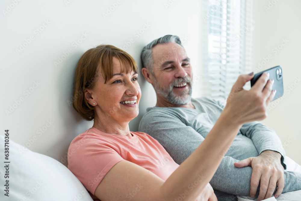 Caucasian senior old couple take a selfies together in bedroom at home. 