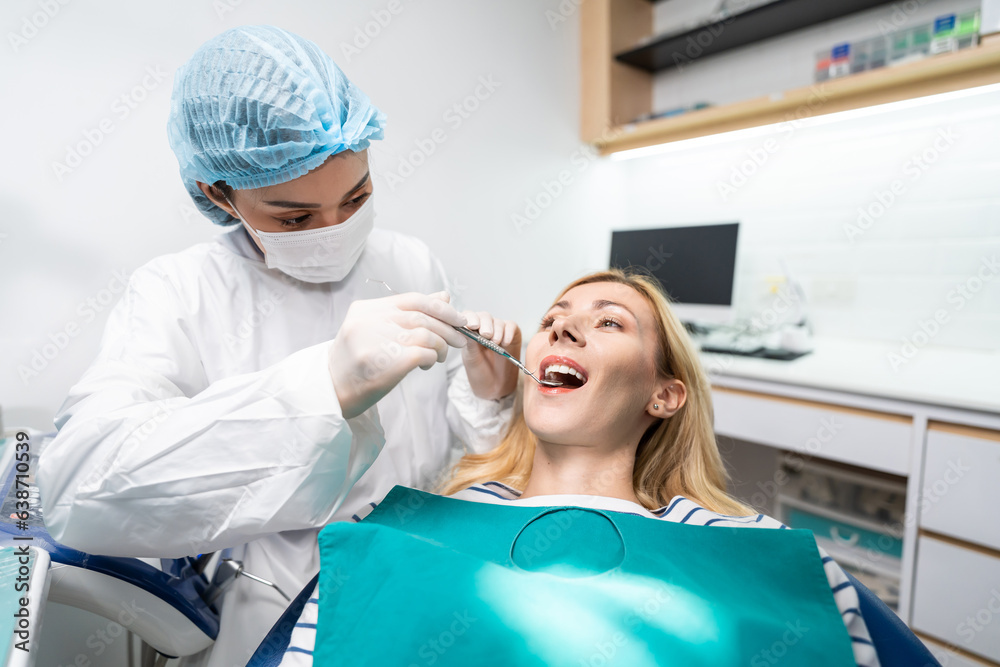 Female dentist examine tooth to Caucasian girl at dental health clinic. 