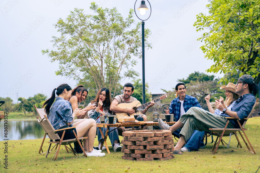 Group of diverse friend having outdoors camping party together in tent.