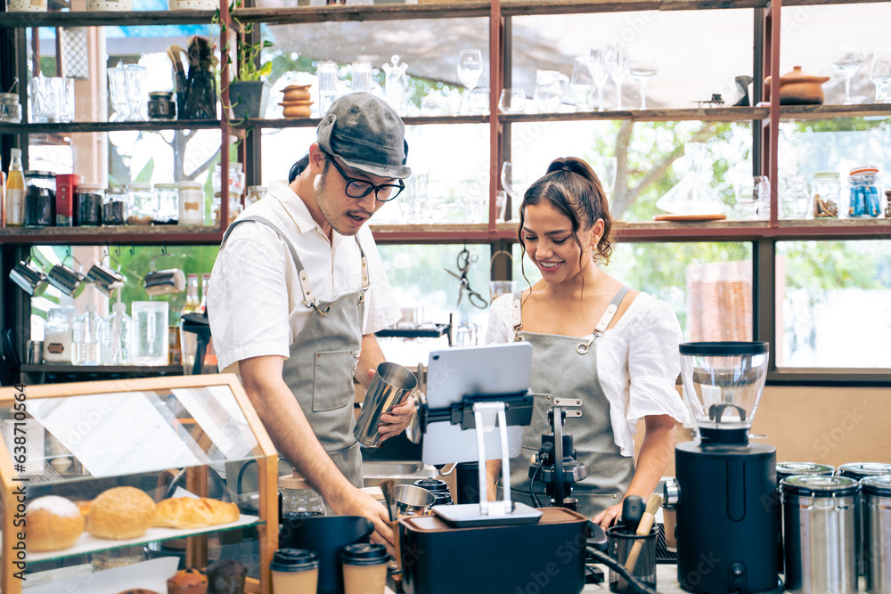 Asian attractive male barista and waitress work in coffeehouse shop. 