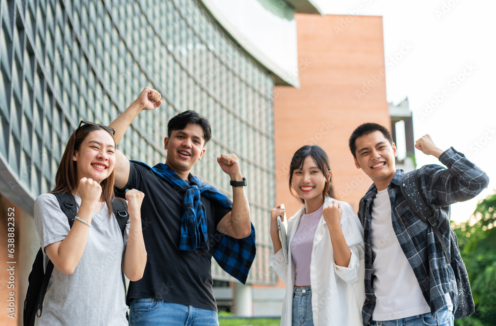 Group of happy young entrepreneurs with hands up and laughing to celebrate and excited success for a