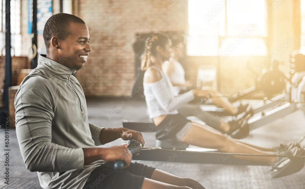 Exercise, happy man and rowing machine in gym for group class, fitness workout and cardio training. 