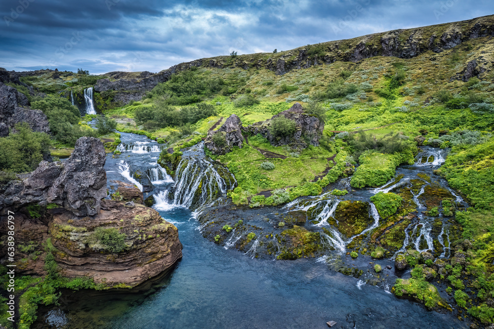 Gjain waterfall flowing in Pjorsardalur lush valley during summer at Iceland