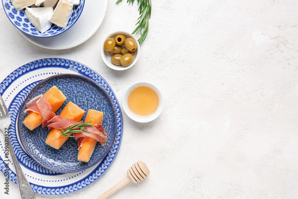 Composition with tasty melon, prosciutto, honey and cheese on light background